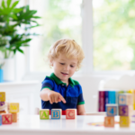 young boy playing with ABC blocks learning letter recognition