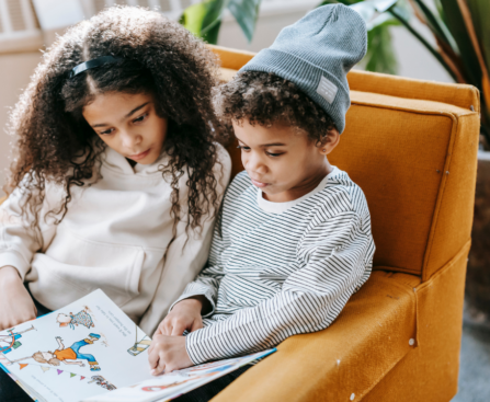 two young children reading a decodable book for beginners