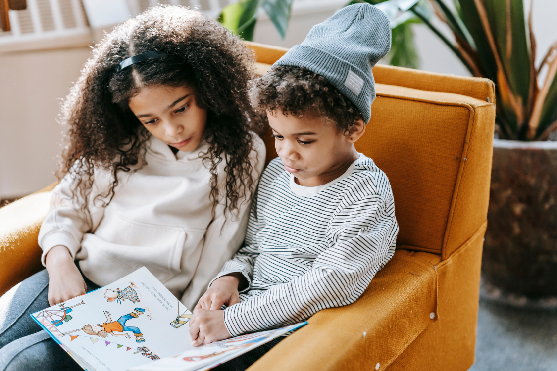 two young children reading a decodable book for beginners