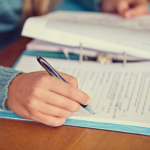 flatlay photo of someone writing in a document to record reading assessment results