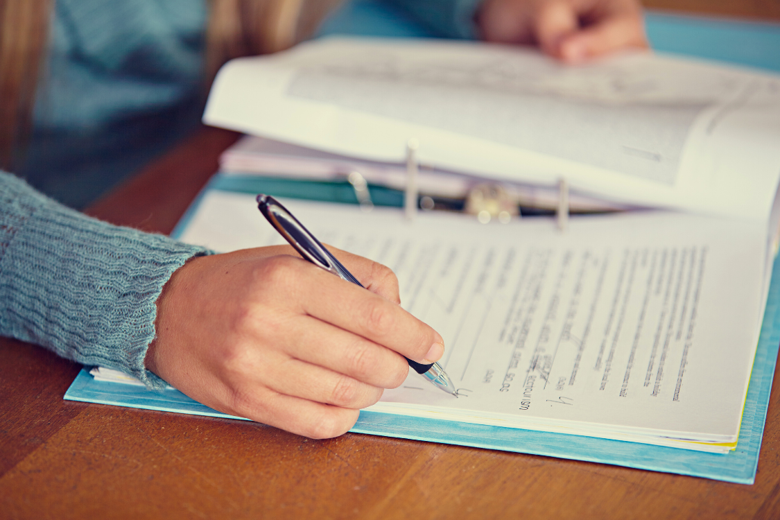 flatlay photo of someone writing in a document to record reading assessment results